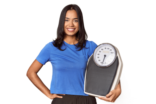 Filipino woman with scale in studio showing a copy space on a palm and holding another hand on waist.