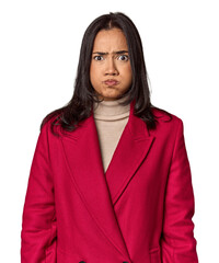 Young filipino woman blows cheeks, has tired expression. Facial expression concept.