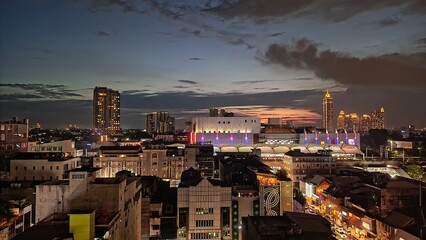 A stunning cityscape at dusk with illuminated buildings and busy streets, perfect for urban, travel, and nightlife themes