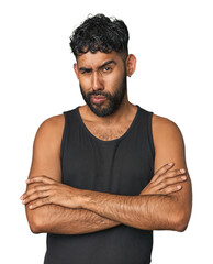 Young Hispanic man isolated frowning face in displeasure, keeps arms folded.