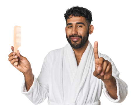 Hispanic male with comb in studio showing number one with finger. - Powered by Adobe