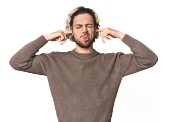 Young Caucasian man in studio setting covering ears with fingers, stressed and desperate by a loudly ambient.