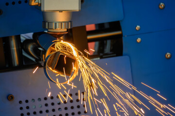 Close up scene the fiber laser cutting machine cut the stainless steel tube with sparkling light.