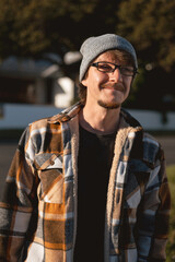 Happy Man in Plaid warm Shirt, Beanie and Glasses in Suburban Setting