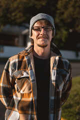 Happy Man in Plaid warm Shirt, Beanie and Glasses in Suburban Setting
