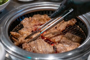 Korean Style Barbecue on stainless grill. BBQ rare meat with soft focus