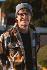 Happy Man in Plaid warm Shirt, Beanie and Glasses in Suburban Setting