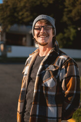 Happy Man in Plaid warm Shirt, Beanie and Glasses in Suburban Setting