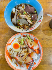 Close up rice crispy pork, roasted red pork, Scallion and boiled egg with sauce in white plate on table background