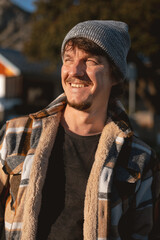 Happy Man in Plaid warm Shirt and Beanie in Suburban Setting