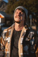 Happy Man in Plaid warml Shirt and Beanie in Suburban Setting