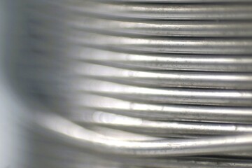 Close-up of a coil of shiny metal wire.  Perfect for industrial, technological, or abstract...