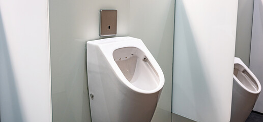 Sensor-operated urinals with privacy walls in a public toilet