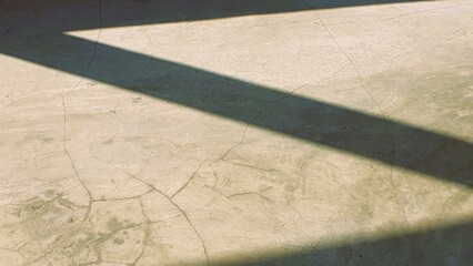 Abstract image of cracked concrete floor with diagonal shadow. Perfect for backgrounds, textures,...