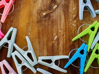 Colorful plastic clothespins on a rustic wooden background. Perfect for craft, laundry, or home...