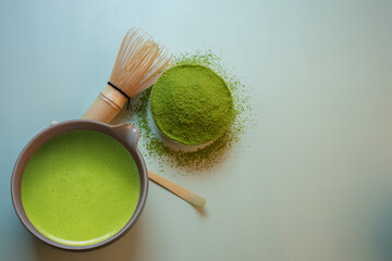 The Matcha green tea on a pastel green background, shot in still life style.