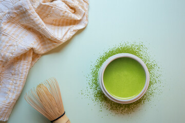 The Matcha green tea on a pastel green background, shot in still life style.