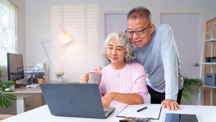 Obraz premium Happy Asian Older Couple Enjoying Retirement Life at Home Using Laptop Together Senior Couple Communication Online Shopping and Relationship