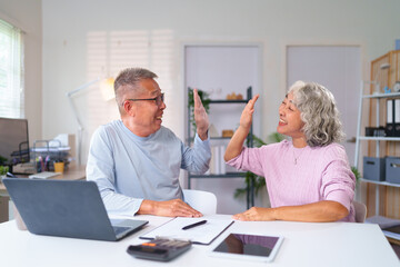 Fototapeta premium Cheerful Asian Older Couple Giving High Five at Home Office Celebrating Success Happy Elderly People Enjoying Retirement Life Achieve Goals Together