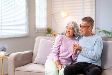Asian Older Couple Enjoying Life at Home Senior Couple Bonding on Sofa Elderly Couple Sharing Moments of Joyful Love Relationship at Retirement Happiness