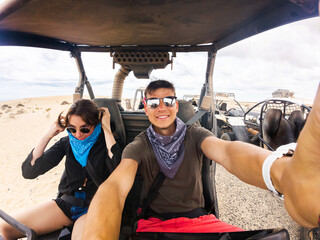 Two friends prepare for a thrilling off-road ride in the desert. They are dressed for adventure,...