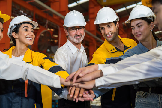 Workers, teamwork and cooperation. Workers join their hands together in industry factory. Unity and teamwork concept