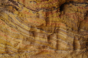Closeup, abstract details of colorful sand and rock, mineral-rich formations in the Colored Sands Nature Reserve in the Negev Desert of southern Israel.