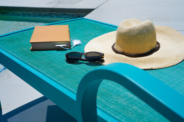 Hat and book on poolside lounge chair in Palm Springs