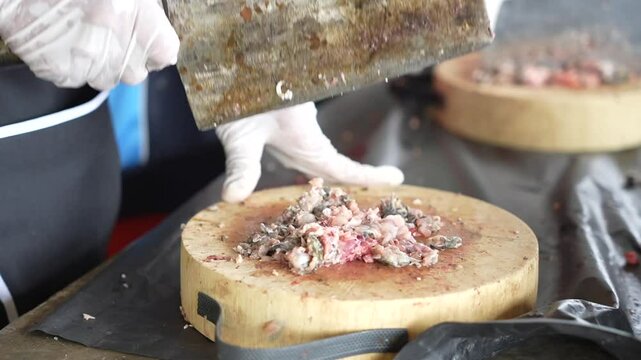 Use a knife to chop the meat on a cutting board.
