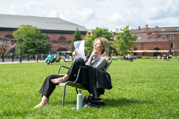 Woman suffering from heat breathing heavily, trembling sweater collar, trying to cool down, cope with discomfort feeling, sensation. Mature female under summer sun in park suffer from stuffiness