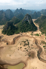 Aerial view of God's eye mountain in Kaobang province of Vietnam. Dry riverbed winding through parched landscape, highlighting the impact of drought on the environment