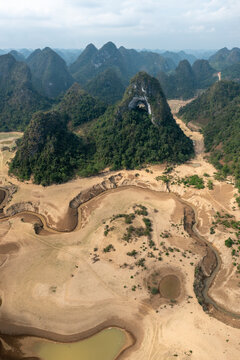 Aerial view of God's eye mountain in Kaobang province of Vietnam. Dry riverbed winding through parched landscape, highlighting the impact of drought on the environment