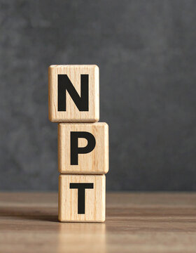 Wood cubes with abbreviation text NPT. Nuclear Non-Proliferation Treaty. National Pipe Thread.