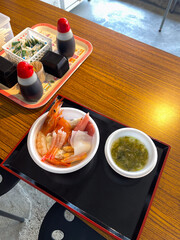 A seafood bowl in Aomori, Japan, showcases fresh shrimp, squid, and sashimi. Served with seaweed...
