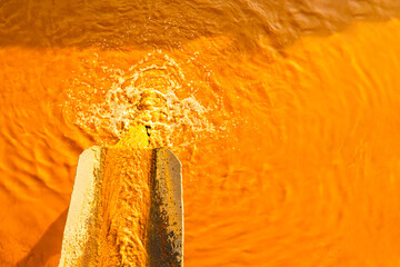  dirty orange water flows down the pipe. Dirty water discharge. water pollution. environmental...