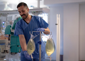 Male nurse preparing iv drip bags in hospital room