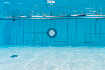 Clean blue water in a swimming pool, view from under the water. An ideal background for concepts of...