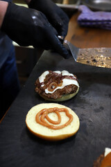hamburguesa de carne con queso fundido y cebolla caramelizada con salsa en la parte de pan brioche