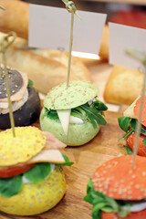 panecillo de medianoche de color verde con sésamo rellena de queso y vegetales