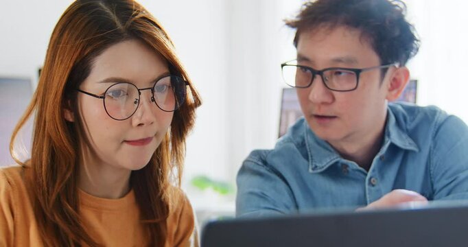 Asian male, female programming developer work together at home office, brainstorm discussion. Information technology, software engineer programmer coding job, man and woman coworker teamwork concept