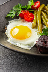 English breakfast fried egg, black pudding, vegetables, beans fresh delicious gourmet food background on the table rustic food top view copy space