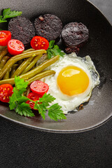 English breakfast fried egg, black pudding, vegetables, beans fresh delicious gourmet food...