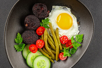 English breakfast fried egg, black pudding, vegetables, beans fresh delicious gourmet food background on the table rustic food top view copy space