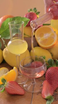 Creative composition featuring strawberry-infused limoncello served in elegant glasses, surrounded by fresh lemons, oranges, and ripe strawberries. Concept of alternative limoncello FullHD footage