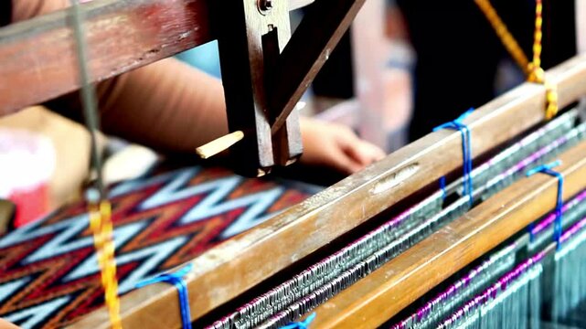 Making tenun ikat Bandar, Indonesia. An Indonesian woman weaving traditional fabric. Traditional weaving cotton in Indonesia.