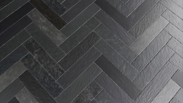 Top-down view of modern dark gray slate tiles with a natural texture laid in a herringbone pattern
