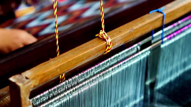 Making tenun ikat Bandar, Indonesia. An Indonesian woman weaving traditional fabric. Traditional weaving cotton in Indonesia.
