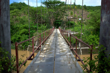 A narrow old hanging bridge in the forest in Gunung Kidul, Yogyakarta, Indonesia