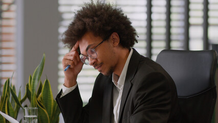Pensive thinking think thought African American man business male guy businessman employer entrepreneur holding paper document result research analyze company budget finance working laptop in office