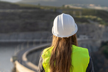 Female engineer inspecting a dam for occupational safety and risk prevention